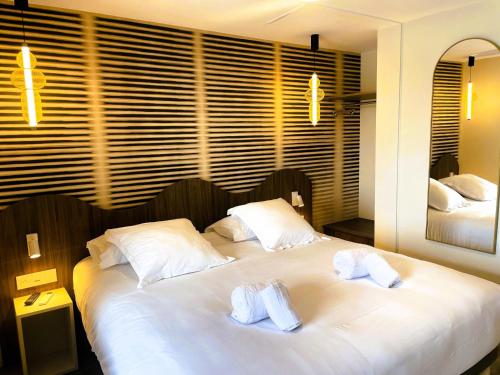 a bedroom with two beds with towels on them at Best Western Hotel Le Crystal Dinard in Dinard