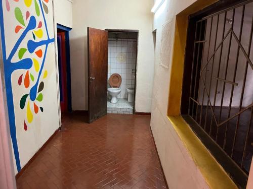 a hallway with a toilet in a room with a door at La mansion caballero hostal in Asunción