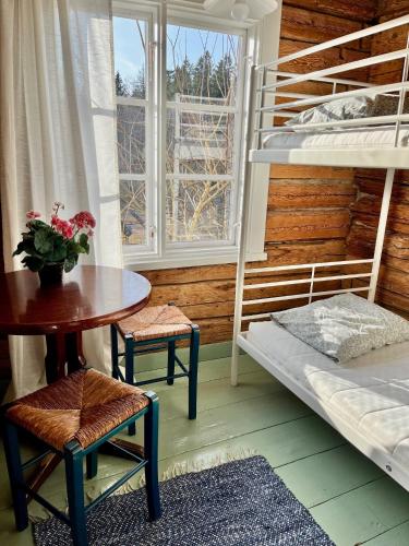 a room with bunk beds and a table and a tableablish at Ahtelan torppa 1 in Salo