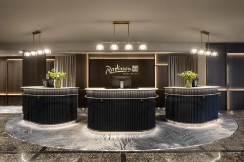 a lobby of a hotel with two counters with plants at Radisson Blu Royal Hotel, Helsinki in Helsinki