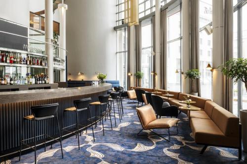 a lobby with a bar and chairs and windows at Radisson Blu Royal Hotel, Helsinki in Helsinki