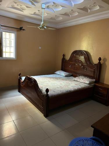 a bedroom with a large wooden bed in a room at Room 11 in Kololi
