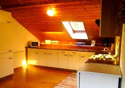 a kitchen with white cabinets and a ceiling with a window at Gästehaus Erlhof in Schiefling am See