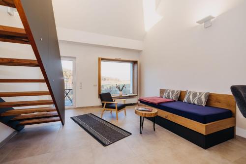 a living room with a bed and a staircase at Mühlenhof Franken in Kirchheim