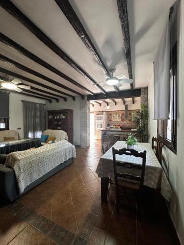 a bedroom with a bed and a table in a room at Chalet vacacional con piscina privada in Arriate