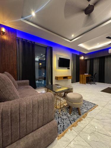 a living room with a couch and a tv at Hotel Namaste With Jacuzzi in Ghaziabad