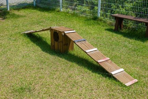 a wooden ramp sitting in the grass next to a bench at Glamdog - Gapyeong in Gapyeong