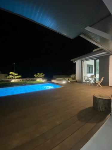 an image of a backyard at night with a swimming pool at le paradis vert bleu in Saint-Paul