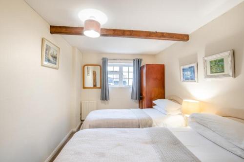a bedroom with two beds and a window at Hunston Mill Self Catering Dog Stay For Free in Chichester