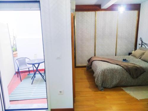a bedroom with a bed and a table in a room at La CASINA de HUGO con Terraza in Luanco