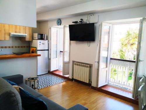 a living room with a couch and a kitchen at La CASINA de HUGO con Terraza in Luanco
