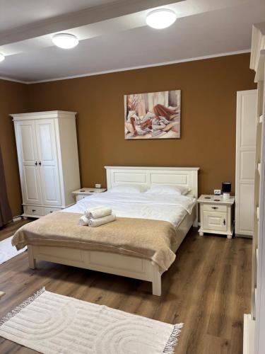 une chambre avec un grand lit blanc et deux tables de chevet dans l'établissement Studio Sunrise, à Sinaia