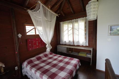 a bedroom with a checkered bed in a wooden room at Casa alquiler en Bombas Bombinhas in Bombas