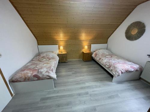 two beds in a small room with wooden ceilings at Schicke Ferien- und Monteurswohnung 53 qm Philippsburg in Philippsburg