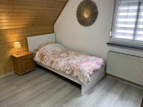 a small bedroom with a bed and a night stand at Schicke Ferien- und Monteurswohnung 53 qm Philippsburg in Philippsburg