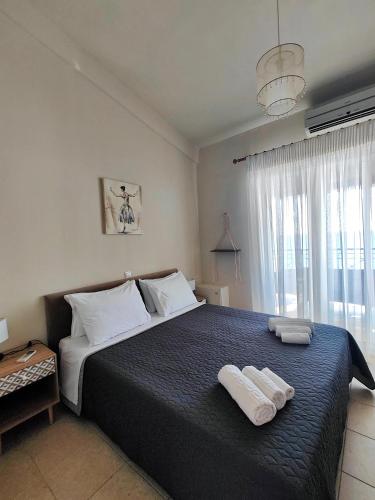 a bedroom with a bed with two towels on it at Golden Horizon Haven in Preveza