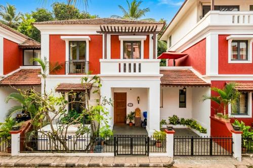 a home with red and white houses at StayVista at Villa Arcadia with Alfresco Dining in Candolim