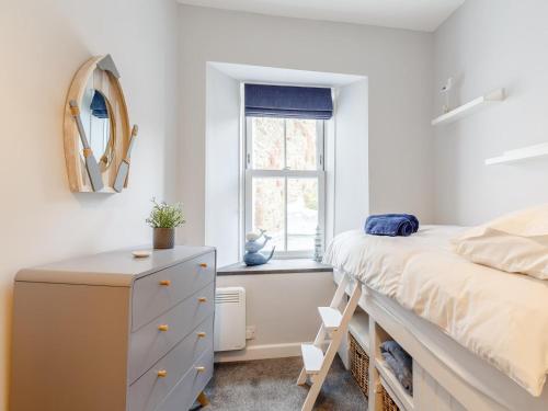 a bedroom with a bed and a dresser and a window at 2 Bed in Polruan oc-82949 in Fowey