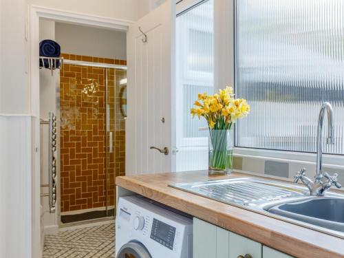 a kitchen with a sink and a washing machine at 2 Bed in Polruan oc-82949 in Fowey