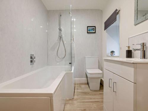 a white bathroom with a tub and a toilet at 2 Bed in Wadebridge oc-83130 in Little Petherick