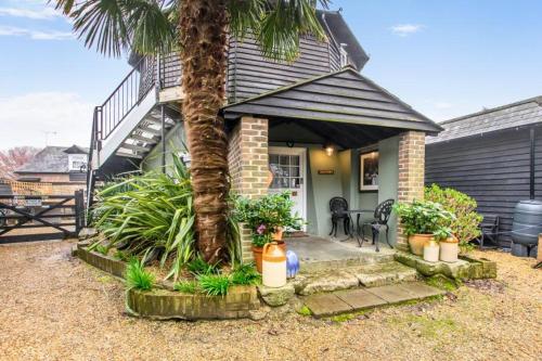 a palm tree in front of a house with a staircase at Hunston Mill Self Catering Dog Stay For Free in Chichester