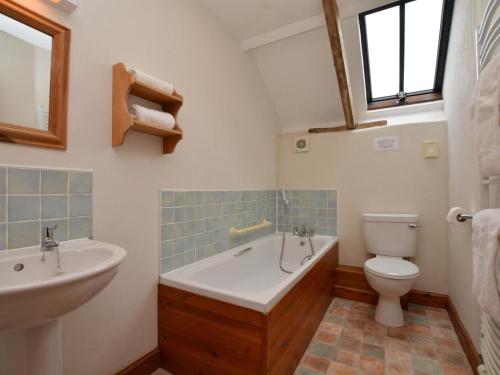 a bathroom with a tub and a toilet and a sink at 2 Bed in Bude oc-coryw in Morwenstow