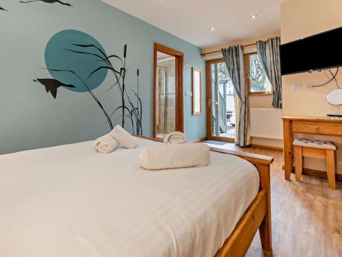 a bedroom with a large bed and a piano at 4 Bed in Newquay oc-56747 in Cubert