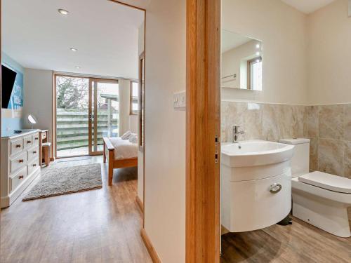 a bathroom with a sink and a toilet and a mirror at 4 Bed in Newquay oc-56747 in Cubert