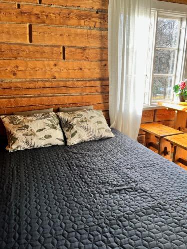 a bedroom with a bed and a wooden wall at Ahtelan torppa 2 in Salo