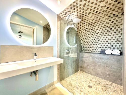 a bathroom with a sink and a shower with a mirror at 1 Bed in Bude oc-88497 in Morwenstow