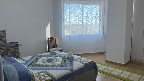 a bedroom with a bed and a large window at Beach Home Retreat in Durrës