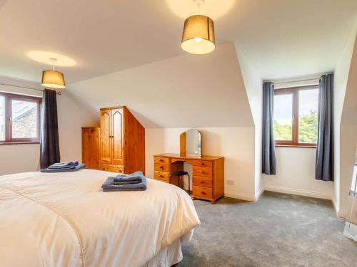 a bedroom with a bed and a dresser and two windows at 4 Bed in Bodmin oc-88543 in Bodmin