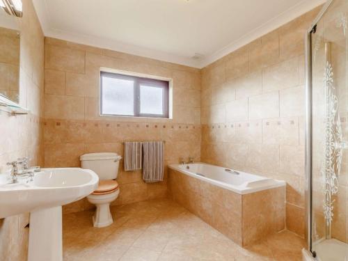 a bathroom with a tub and a toilet and a sink at 4 Bed in Bodmin oc-88543 in Bodmin