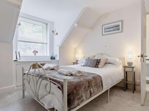 a bedroom with a large bed in a white room at 2 Bed in Looe oc-82537 in Looe