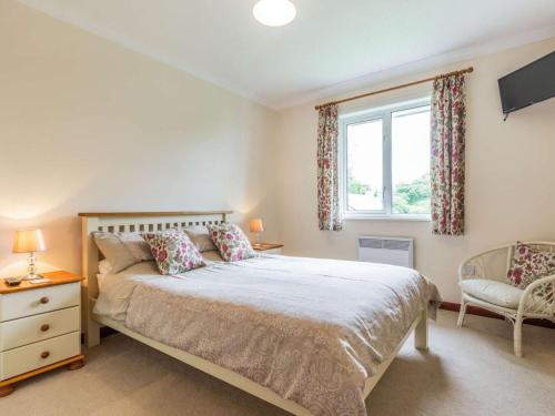 a bedroom with a bed and a window and a chair at 2 Bed in Falmouth oc-tvean in Constantine