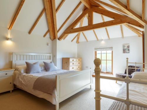 a bedroom with a bed in a room with beams at 3 Bed in Crackington Haven oc-78271 in Saint Gennys