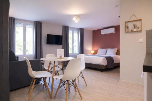 una camera d'albergo con un letto, un tavolo e delle sedie di le saint Hubert ad Arcis-sur-Aube