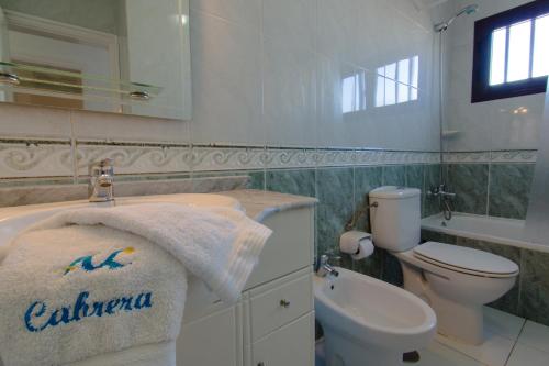 プエルト・デル・カルメンにあるVilla Coronaのバスルーム(洗面台、トイレ、タオル付)