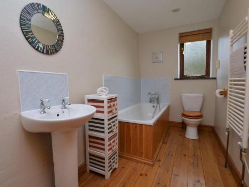 a bathroom with a sink and a tub and a toilet at 2 Bed in Bude oc-coryb in Morwenstow
