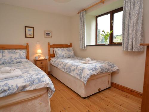 a bedroom with two beds and a window at 2 Bed in Bude oc-coryb in Morwenstow