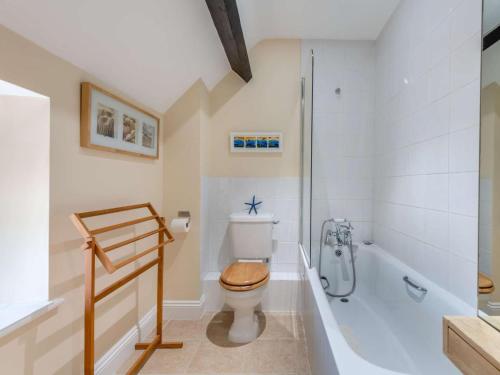 a bathroom with a toilet and a bath tub at 3 Bed in Bridport oc-dc049 in Chideock