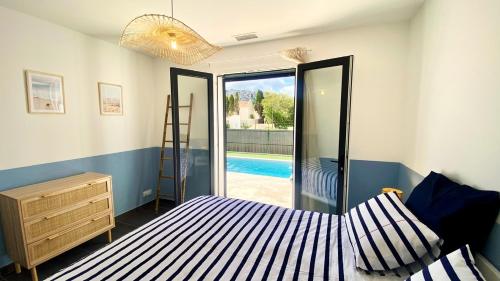 a bedroom with a bed and a view of a pool at Casa Amarante - Piscine privée chauffée - Climatisation - WIFI in Roquefort-des-Corbières