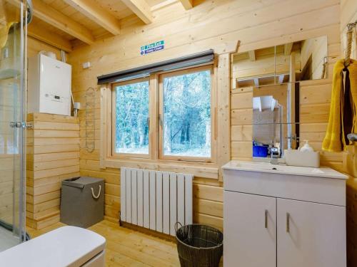 a kitchen in a log cabin with a sink and a window at 2 Bed in Holsworthy oc-87766 in Week Saint Mary
