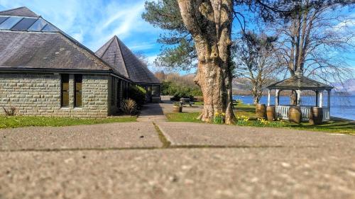a house with a gazebo next to a lake at MAC Skyline Lodges in Balloch