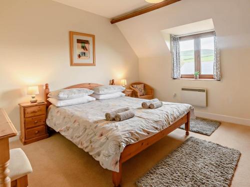 a bedroom with a bed with two pillows on it at 3 Bed in Bridport oc-dc087 in Chideock