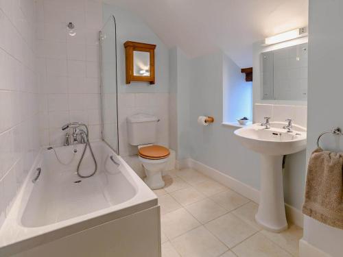 a bathroom with a tub and a toilet and a sink at 3 Bed in Bridport oc-dc087 in Chideock