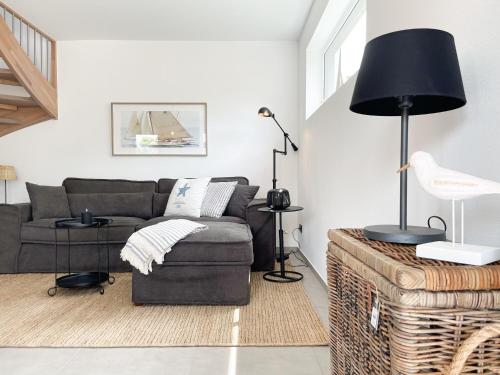 a living room with a couch and a black lamp at Hygge Hus 1 in Timmendorfer Strand