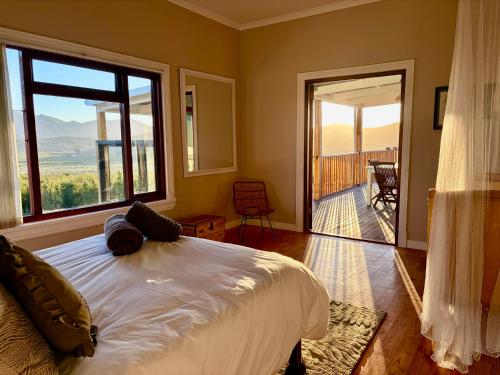 a bedroom with a bed and a large window at Emmie's Cottage in Rietvlei Number 1