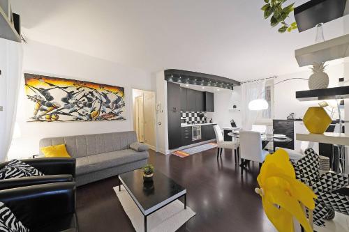 a living room with a couch and a dining room at Downtown Apartment - Gardagate in Salò