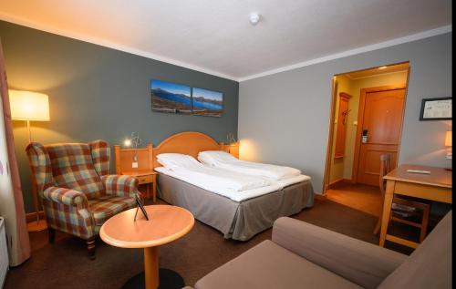 a hotel room with a bed and a chair at Bergo Rom in Beitostøl